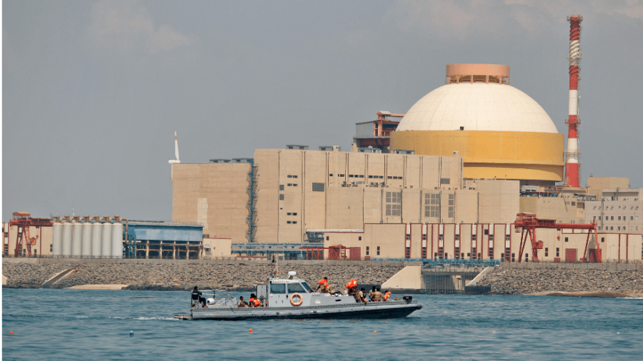 A nuclear power plant with a white dome sits near a body of water.