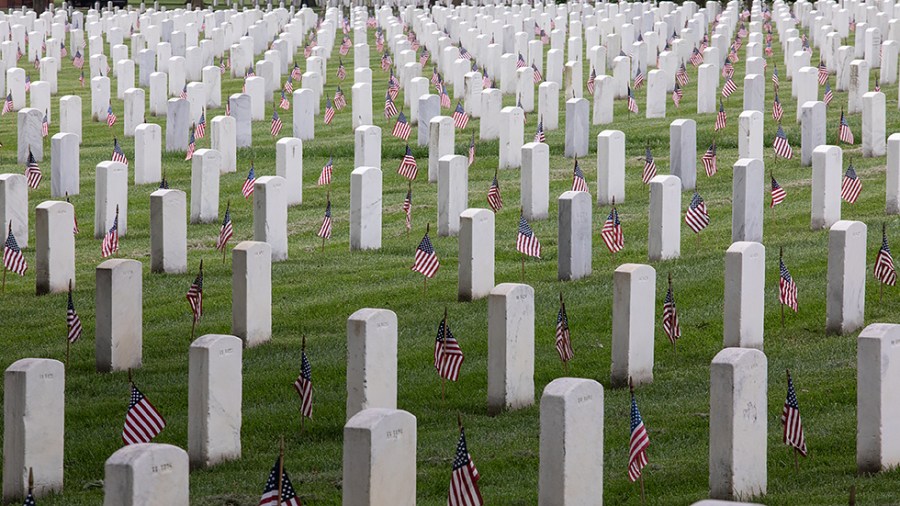 Flags are placed in front of more than 280,000 headstones of U.S. military personnel buried at Arlington National Cemetery, in preparation for Memorial Day, in Arlington, Va., on Thursday, May 26, 2022.