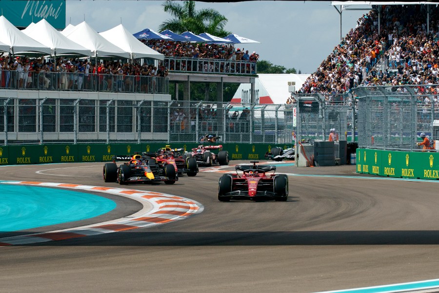 Ferrari driver Charles Leclerc of Monaco leads the pack as a crowd cheers from the stands in the background