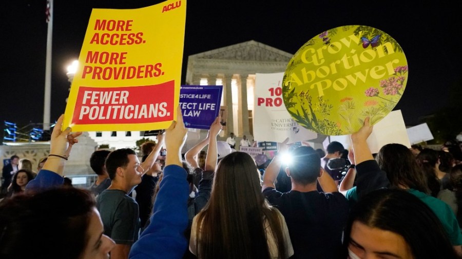 A crowd of people gather outside the Supreme Court, Monday night, May 2, 2002 in Washington