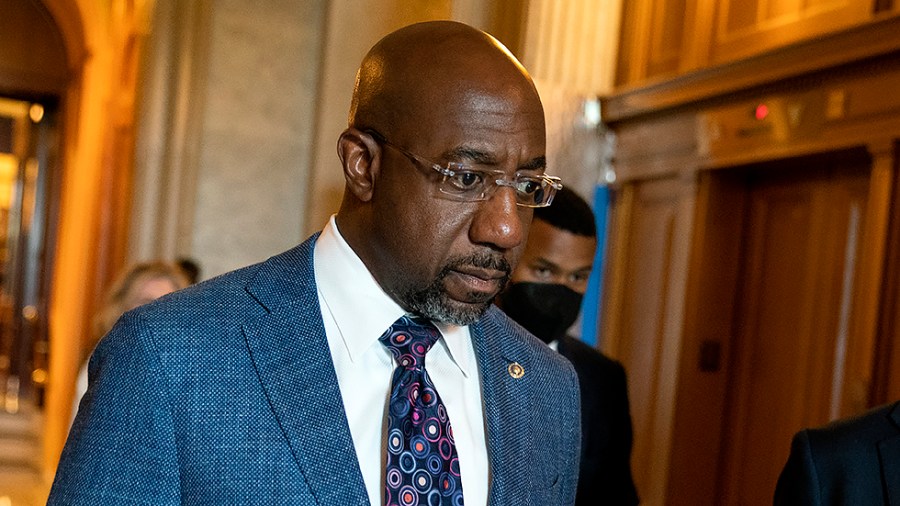 Sen. Raphael Warnock (D-Ga.) speaks to a reporter as he leaves the Senate Chamber following a procedural vote regarding a nomination on Tuesday, May 3, 2022.