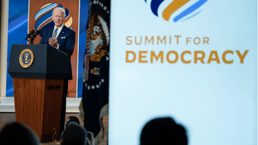 President Joe Biden stands at a podium during the Summit For Democracy.