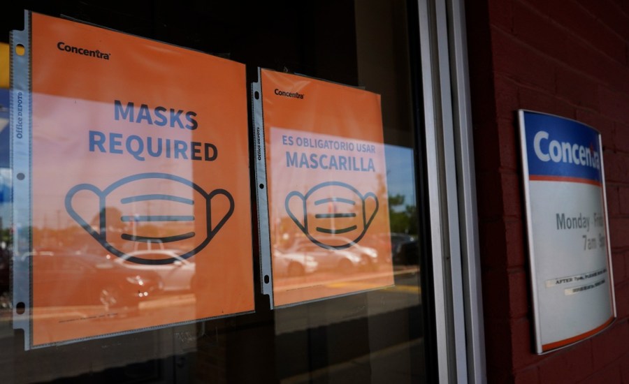 signs about wearing face masks on a door to a clinic