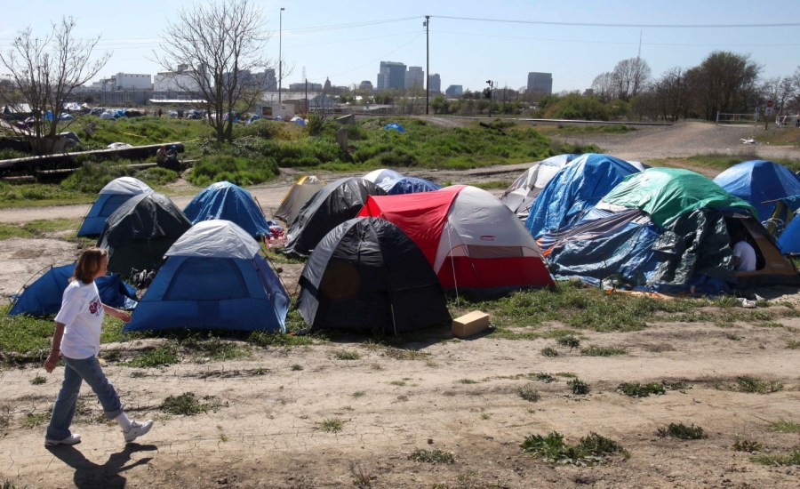 Woman walking past tent city