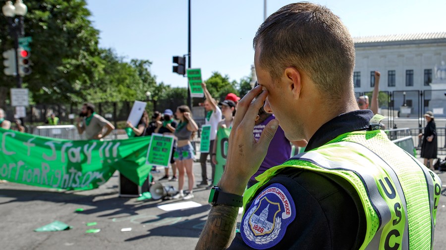 A U.S. Capitol Police officer observes protesters demonstrating in front of the Supreme Court of the United States on June 15, 2022.