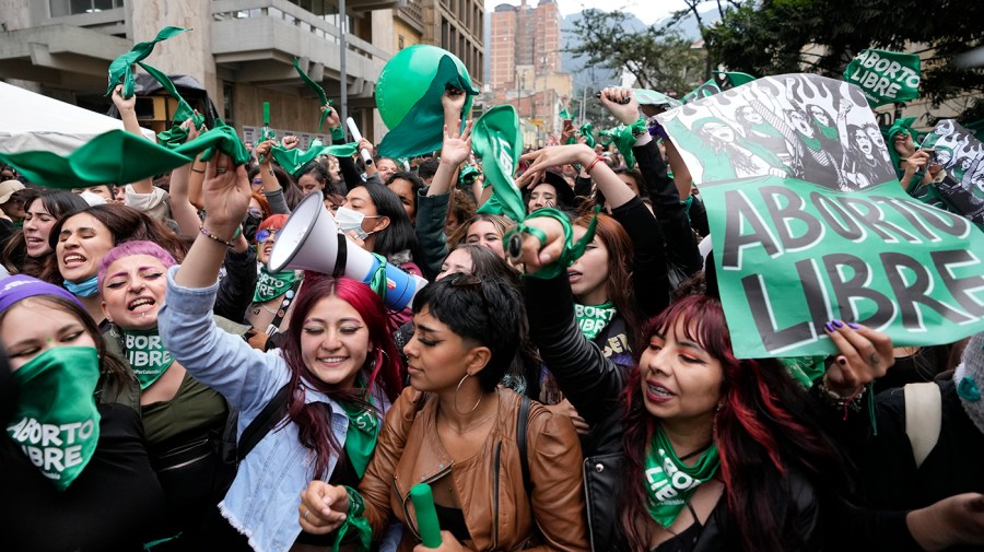 Abortion-rights activists with green signs and accessories celebrate after the Constitutional Court approved the decriminalization of abortion