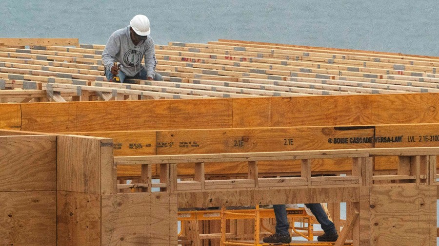 Builders work on a condominium building under construction