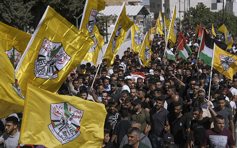 A large crowd of Palestinian mourners help carry the body of Mohammed Abu Ayhour, 27, during his funeral