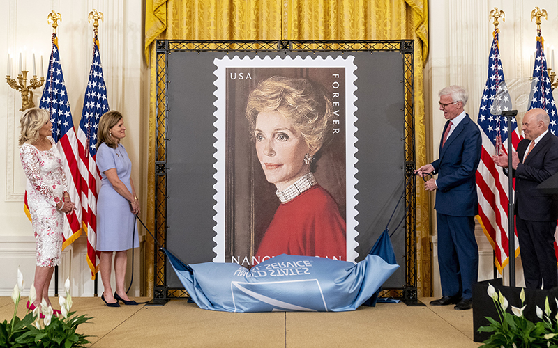 First lady Jill Biden, Postmaster General Louis DeJoy and others unveil a stamp of Nancy Reagan, center