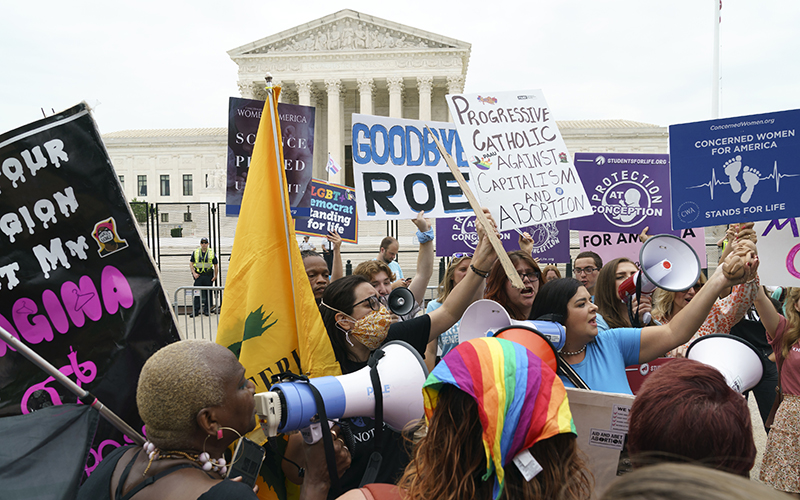 Protesters for and against abortion rights demonstrate with signs and megaphones