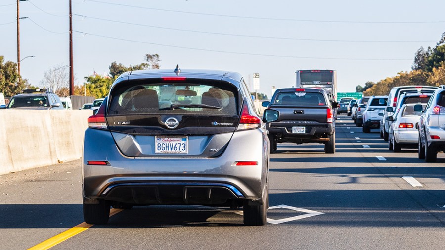 Back view of a Nissan Leaf driving on a highway