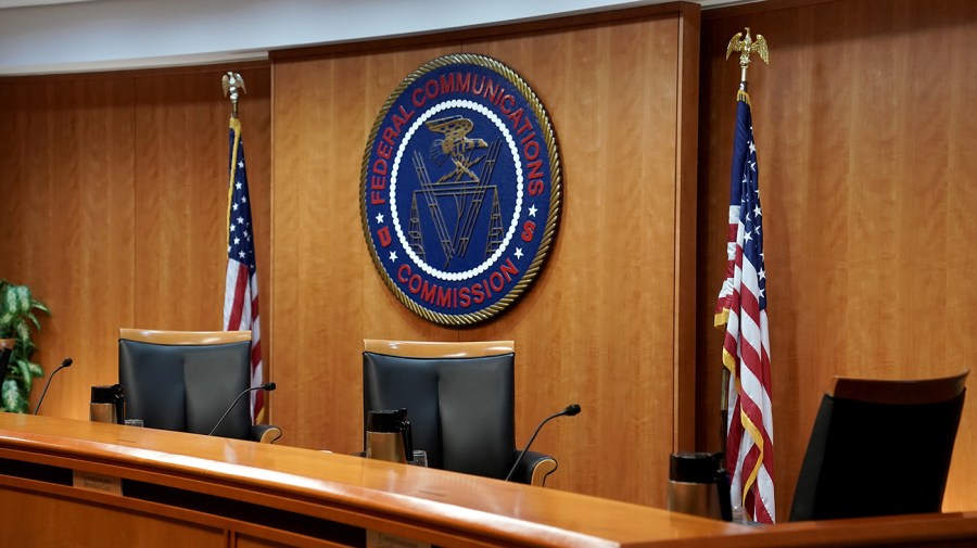 Federal Communications Commission meeting room with seal, flags