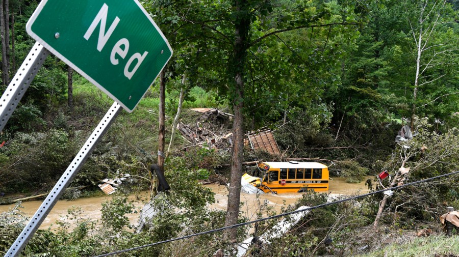 A Perry County school bus lies destroyed after being caught up in the floodwaters of Lost Cree in Ned, Ky.,