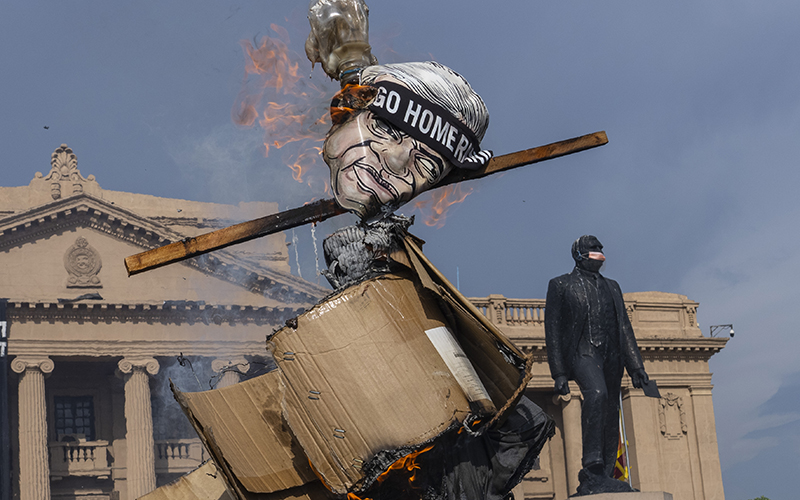 Protesters burn an effigy of Sri Lanka's acting president and prime minister