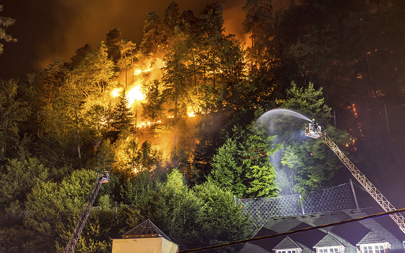 Firefighters throw water on fire in the Ceske Svycarsko National Park