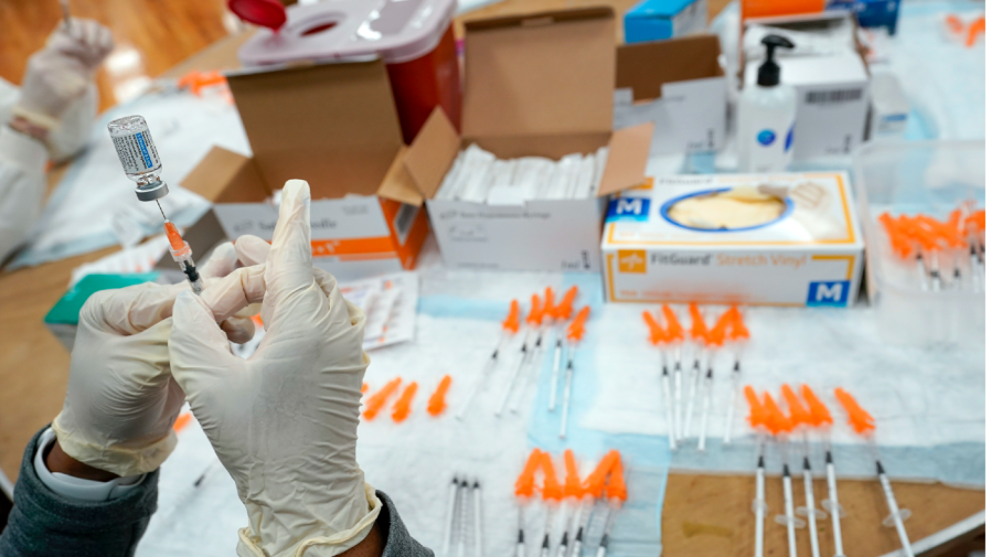 FILE - A Northwell Health registered nurse fills a syringe with a COVID-19 vaccine at a pop up vaccination site the Albanian Islamic Cultural Center, April 8, 2021, in the Staten Island borough of New York.