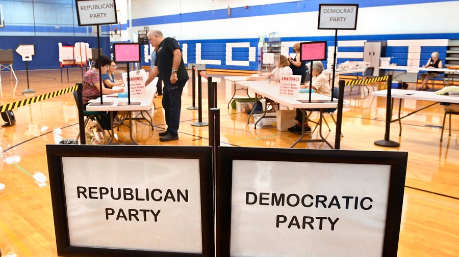 Voters are divided by party affiliation at tables prior to voting.