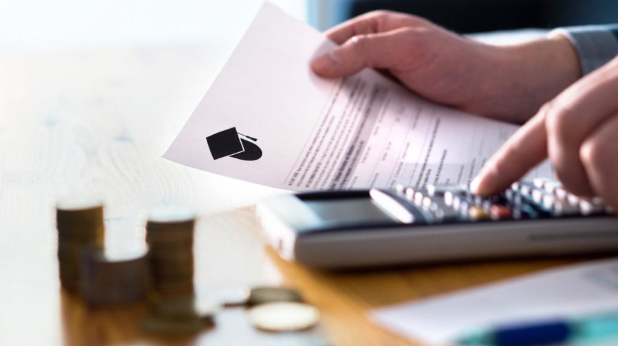 A person uses a calculator while looking at a document in a close-up.