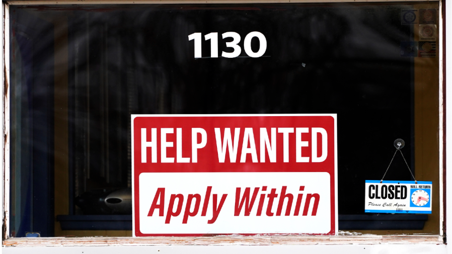 FILE - A "help wanted" sign is seen at an Allstate insurance office in Elgin, Ill., March 19, 2022.