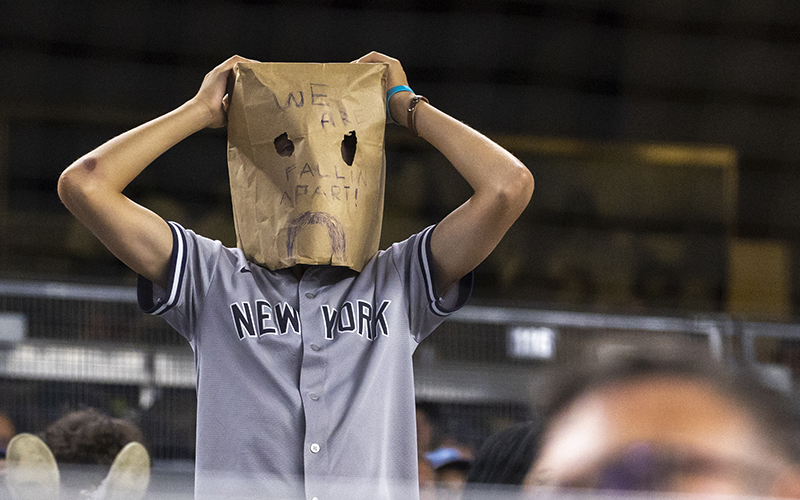 A New York Yankees fan with a paper bag on his head reacts