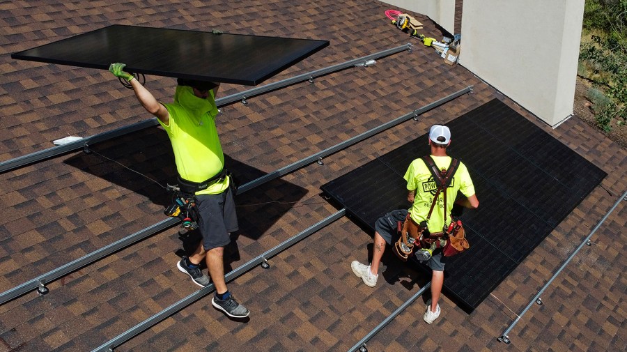 Workman with Power Shift Solar put solar panels on a house Wednesday, Aug. 10, 2022, in Salt Lake City.