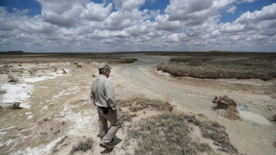 Biologist Jude Smith looks over a nearly dry spring outside Muleshoe, Texas.