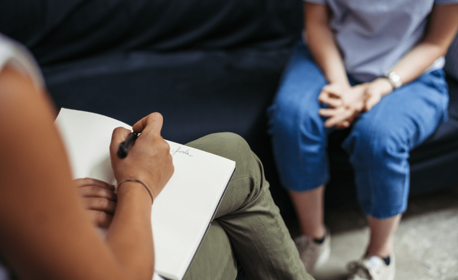 psychiatrist taking notes with patient