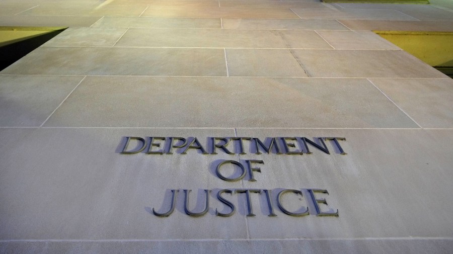 A Department of Justice sign is seen on a building.