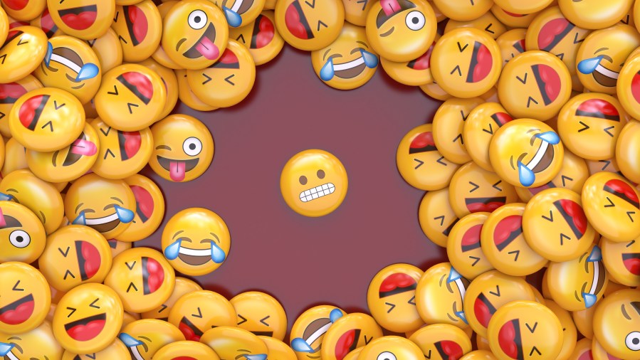 3D rendering of a bunch of laughing emojis surrounding another shamed one