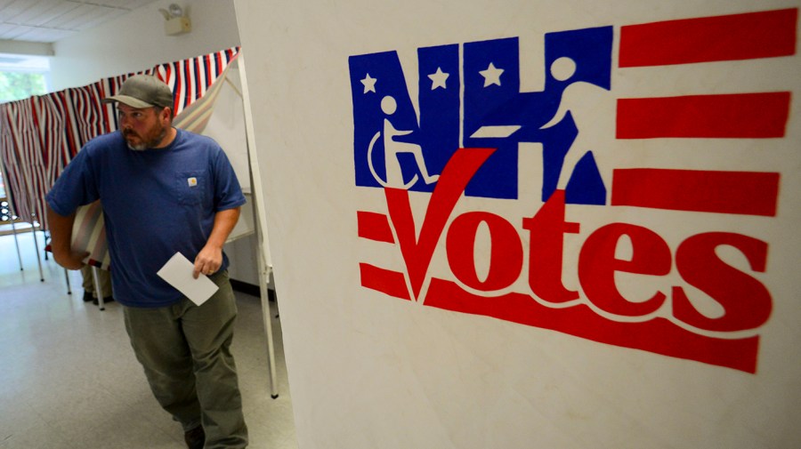 A man leaves a voting booth.