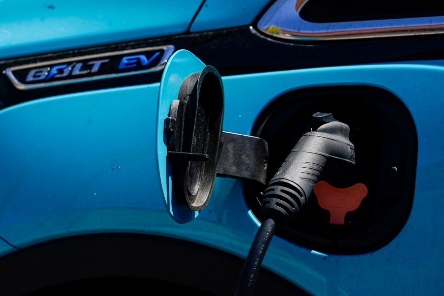 A close-up of a An electric vehicle charges at a shopping center