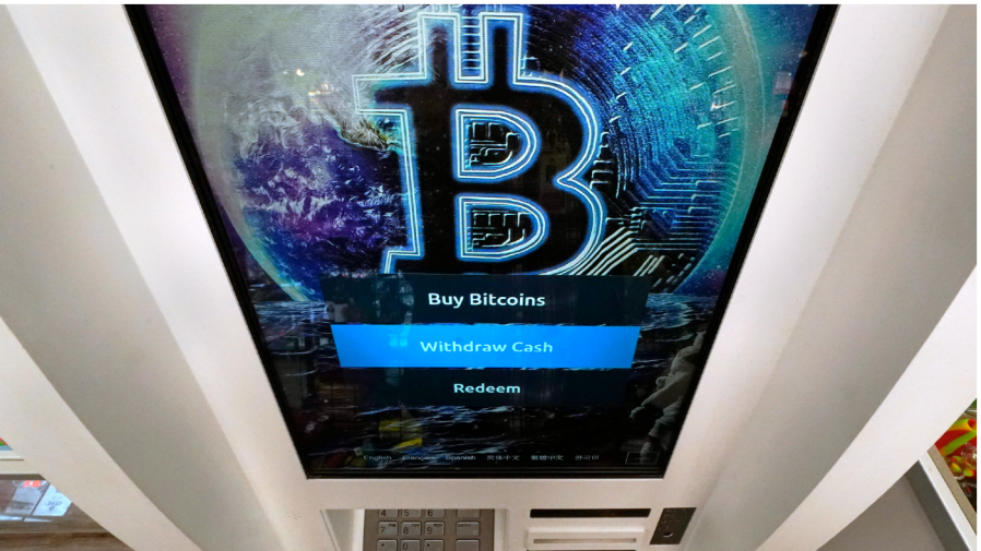 FILE - The Bitcoin logo appears on the display screen of a cryptocurrency ATM in Salem, N.H., Feb. 9, 2021.