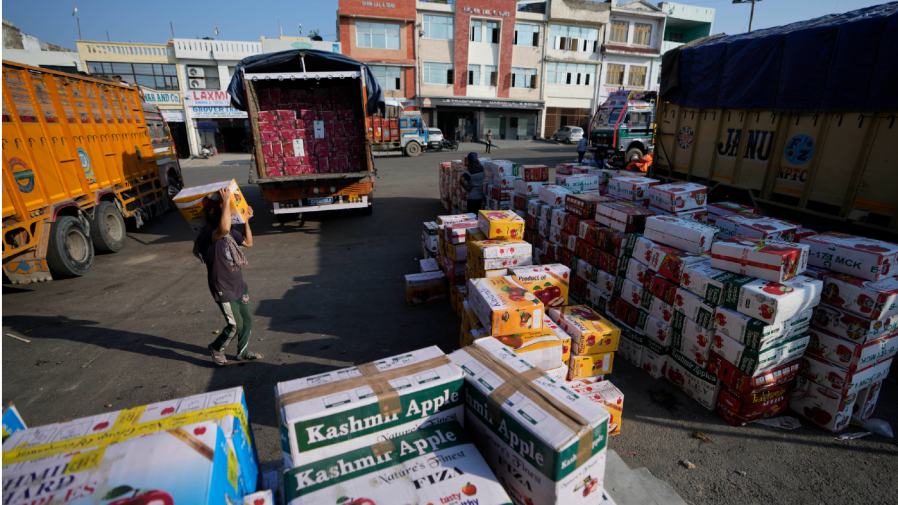 A laborer carries a box of apples at a wholesale market in Jammu, India, Wednesday, Sept. 7, 2022. Jammu and Kashmir is the largest producer of apples in India.