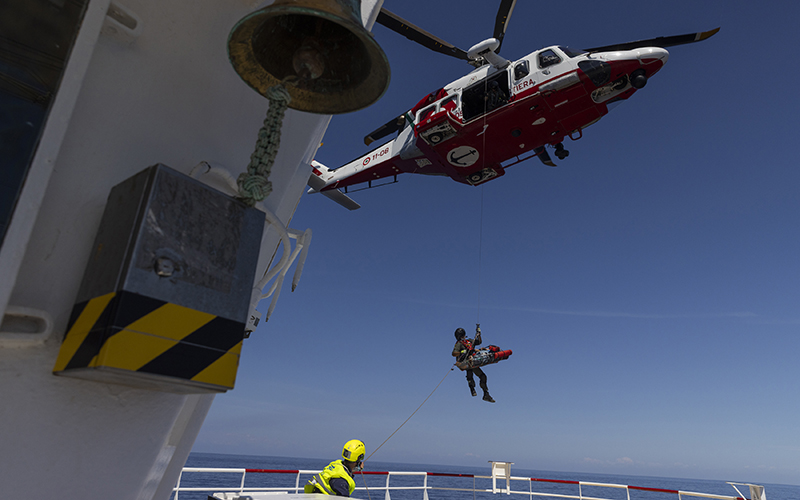 An Italian coast guard helicopter evacuates a pregnant Tunisian woman