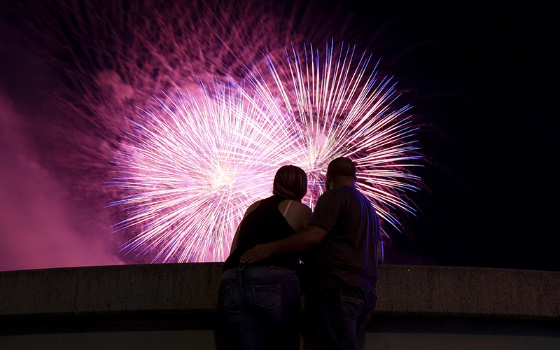 Spectators watch as fireworks are launched over the Ohio River