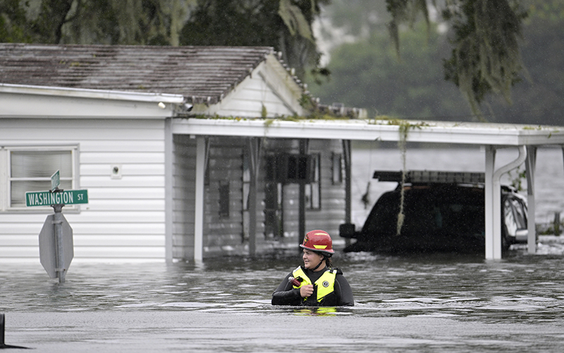 A first responder makes her way through floodwaters after Hurricane Ian in Orlando, Fla.