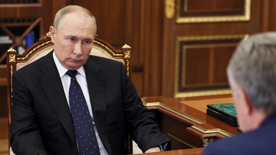 Russian President Vladimir Putin listens during a meeting