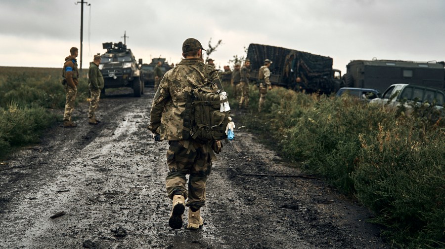 A Ukrainian solder walks down a road