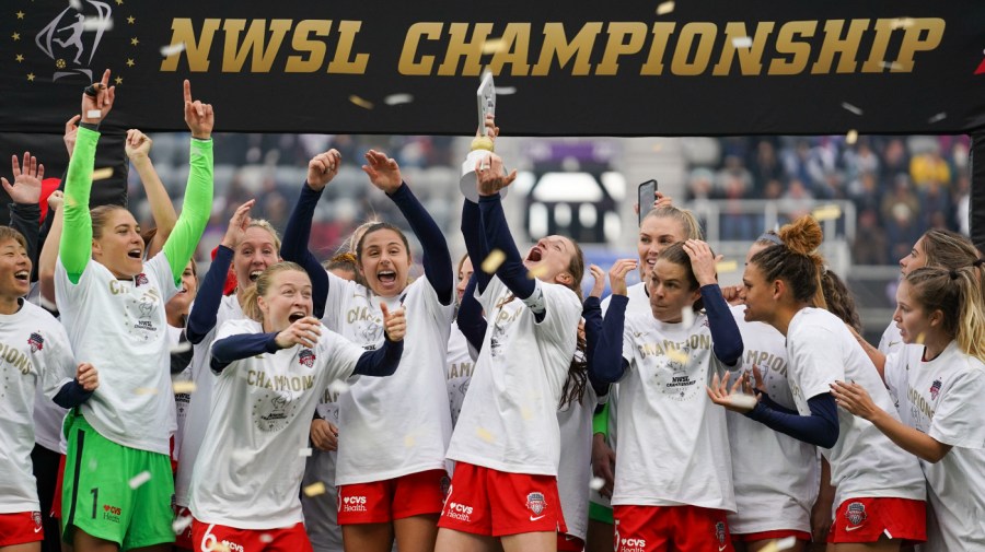 Washington Spirit's Andi Sullivan, center, lifts the trophy