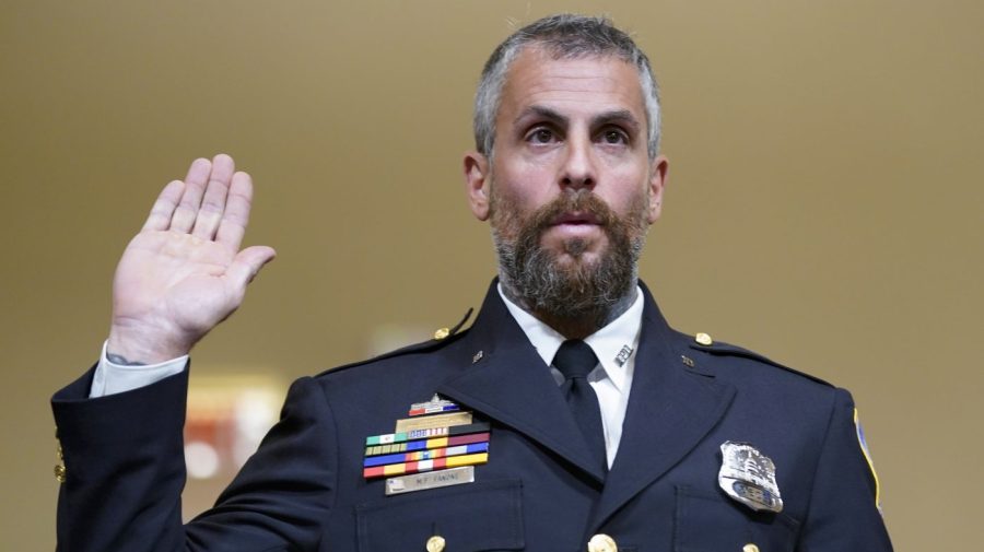 Officer Michael Fanone raises his hand as he is sworn in to testify to a House select committee.