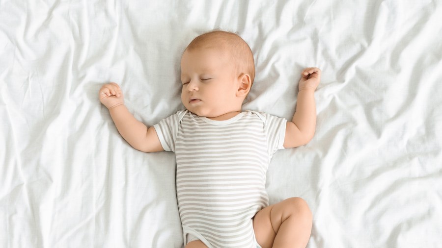 Baby asleep on white sheet