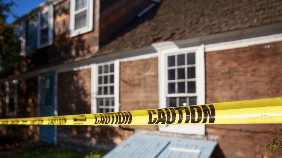 Caution tape blocking the way into the building - stock photo