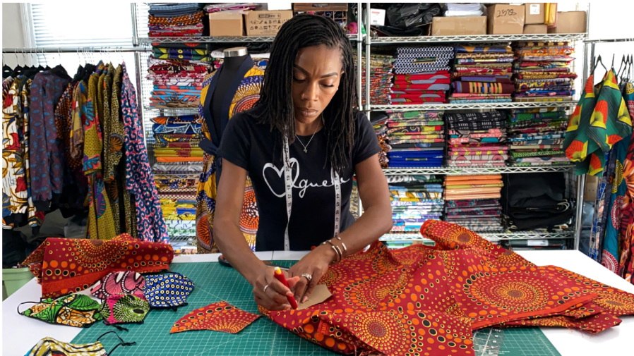 Iguehi James, an Oakland, Calif., fashion entrepreneur, cuts fabric to make a face mask she sells through her apparel company Love Iguehi, Tuesday, Sept. 15, 2020