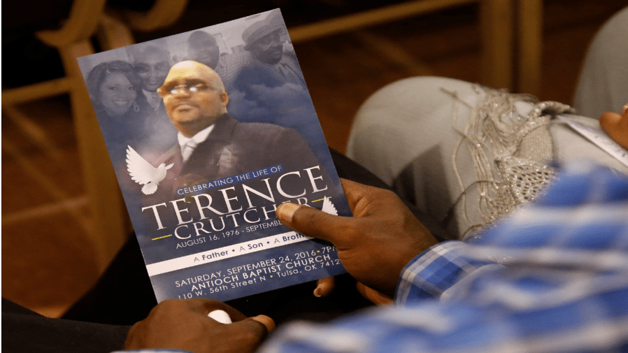 FILE - In this Sept. 24, 2016 file photo, a man holds a copy of the program for the funeral of Terence Crutcher during services to honor him in Tulsa, Okla.