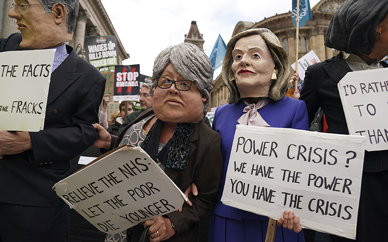 Protesters wearing papier-mâché heads attend a rally in Victoria Square