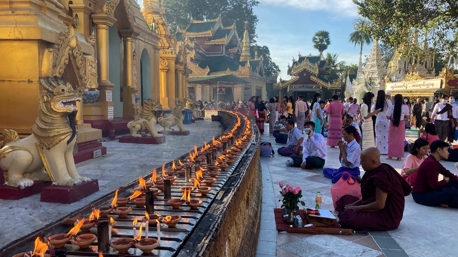 Buddhist devotees and monks pray at the popular Shwedagon Pagoda