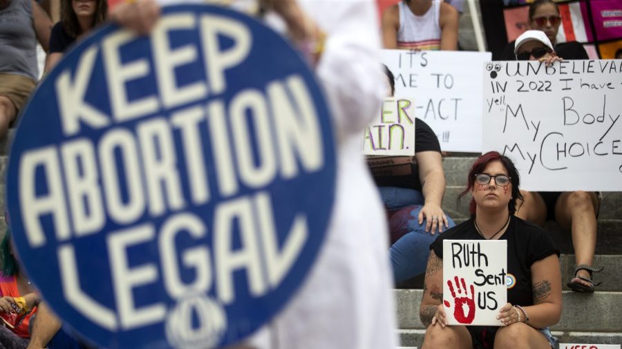 A sign that says "Keep Abortion Legal" is visible as protesters demonstrate during a rally.