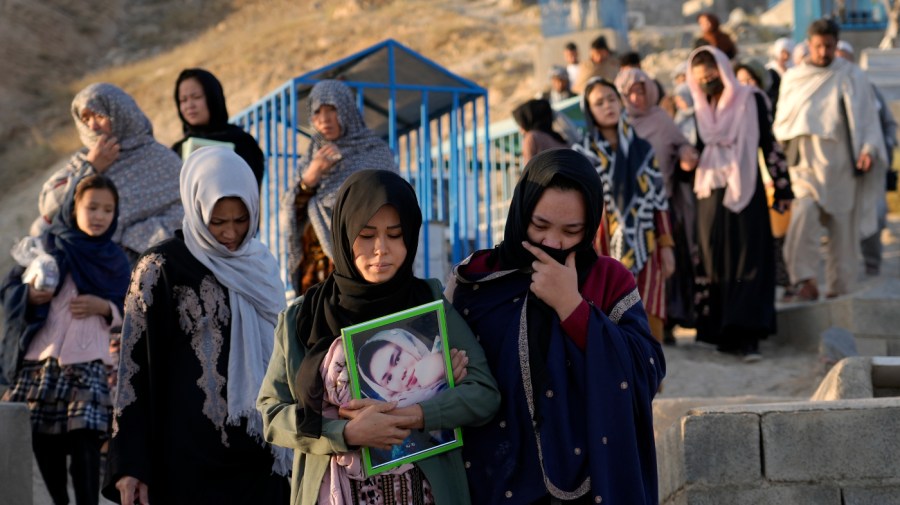 The family of 20-year-old Vahida Heydari, who was a victim of a suicide bombing on a Hazara education center, goes to her grave for a mourning ceremony, in Kabul, Afghanistan