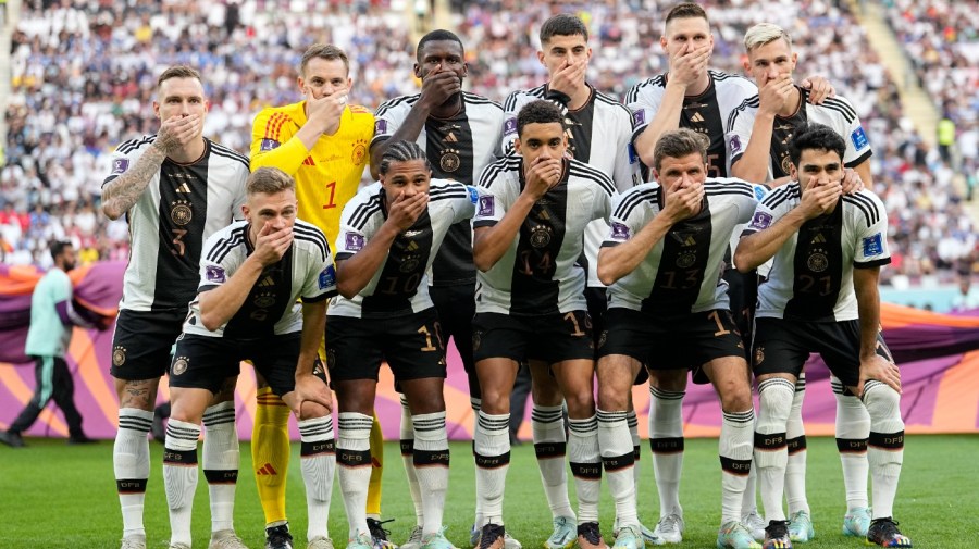 Players from Germany pose for the team photo as they cover their mouth during the World Cup group E soccer match between Germany and Japan, at the Khalifa International Stadium in Doha, Qatar, Wednesday, Nov. 23, 2022.