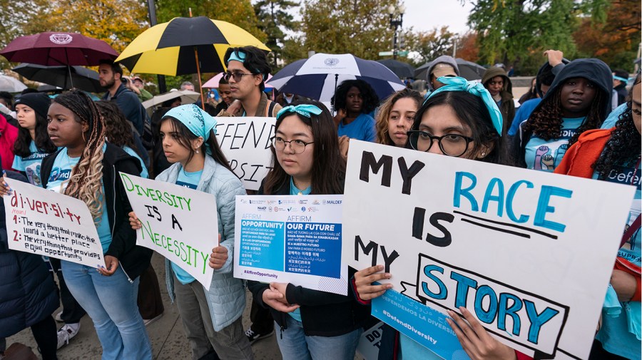 Harvard student Samaga Pokharel, right, and other activists rally as the Supreme Court hears oral arguments